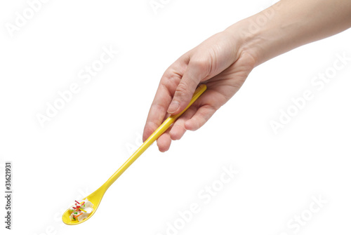 Hand holding a teaspoon full of cream