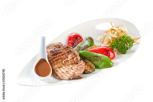 Tasty fried meat served with vegetables and sauce