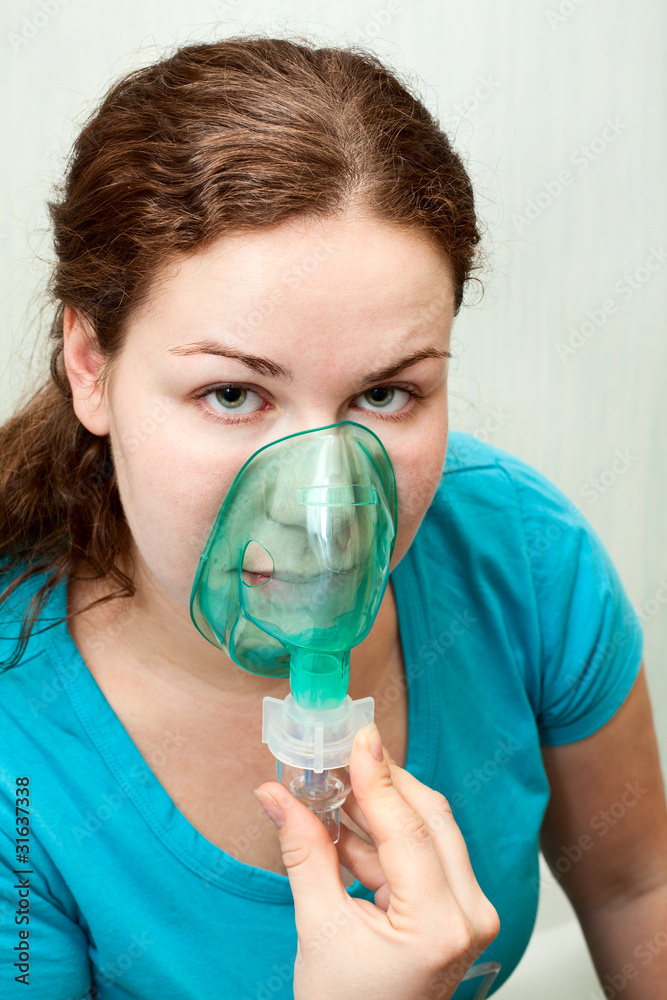Woman in medical inhalation mask breathing