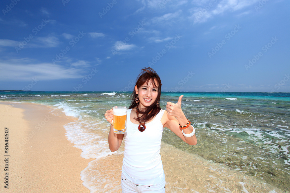 透明なサンゴの海とビールを持った笑顔の女性