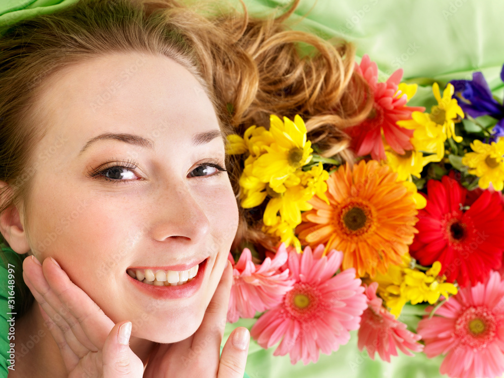 Young woman in flowers touching face. Young woman in flowers touching face.