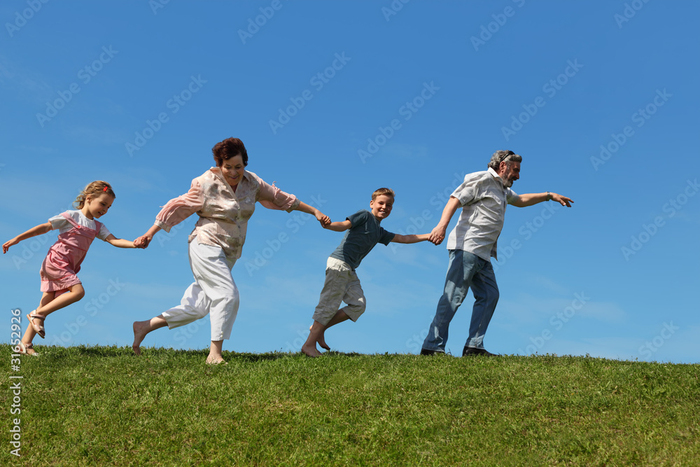 grandchildren and their grandparents running on lawn and holding grandchildren and their grandparents running on lawn and holding