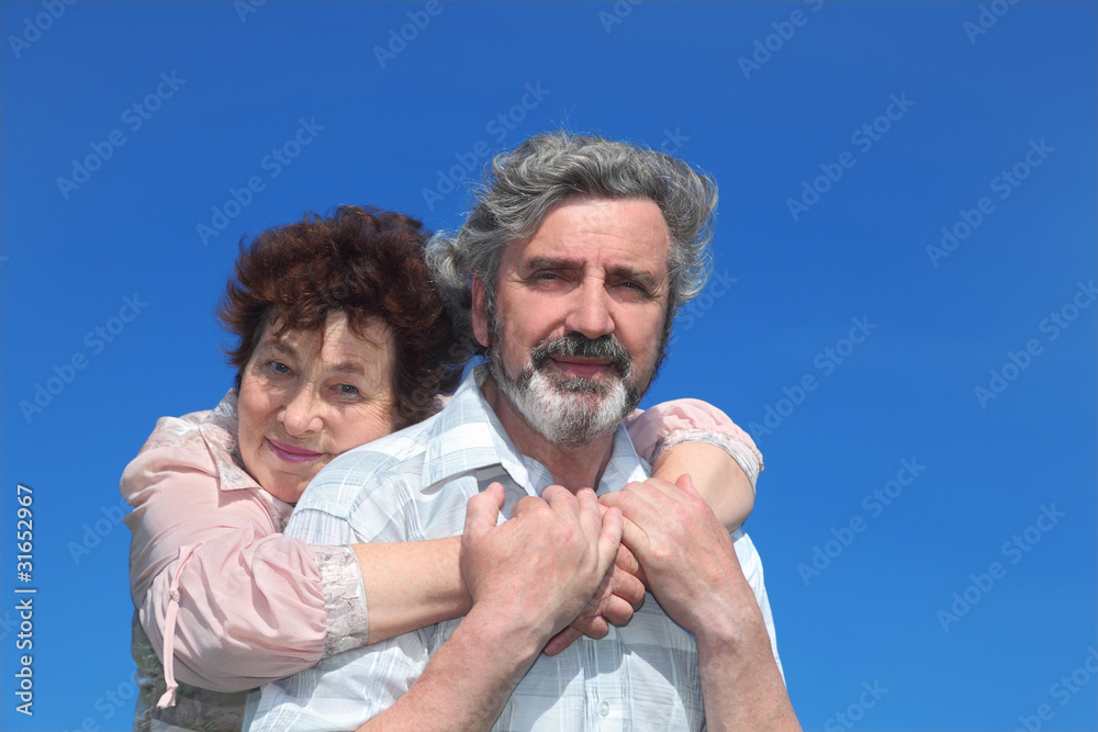 Fototapeta premium old woman embracing man from back, blue sky