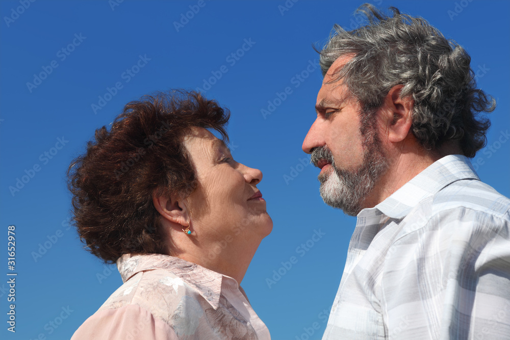 old woman and man looking to each other, blue sky old woman and man looking to each other, blue sky