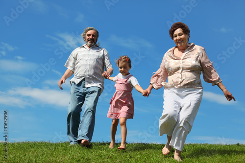 Billede på lærred barefooted  girl and her grandparents running on summer