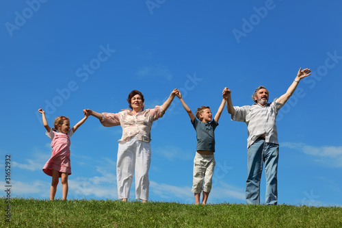 grandchildren and their grandparents standing on lawn and holdin
