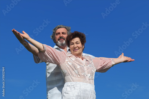 man and woman standing, smiling and looking at camera