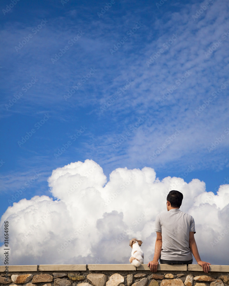 Man sitting with dog and watching the cloud of summer Man sitting with dog and watching the cloud of summer