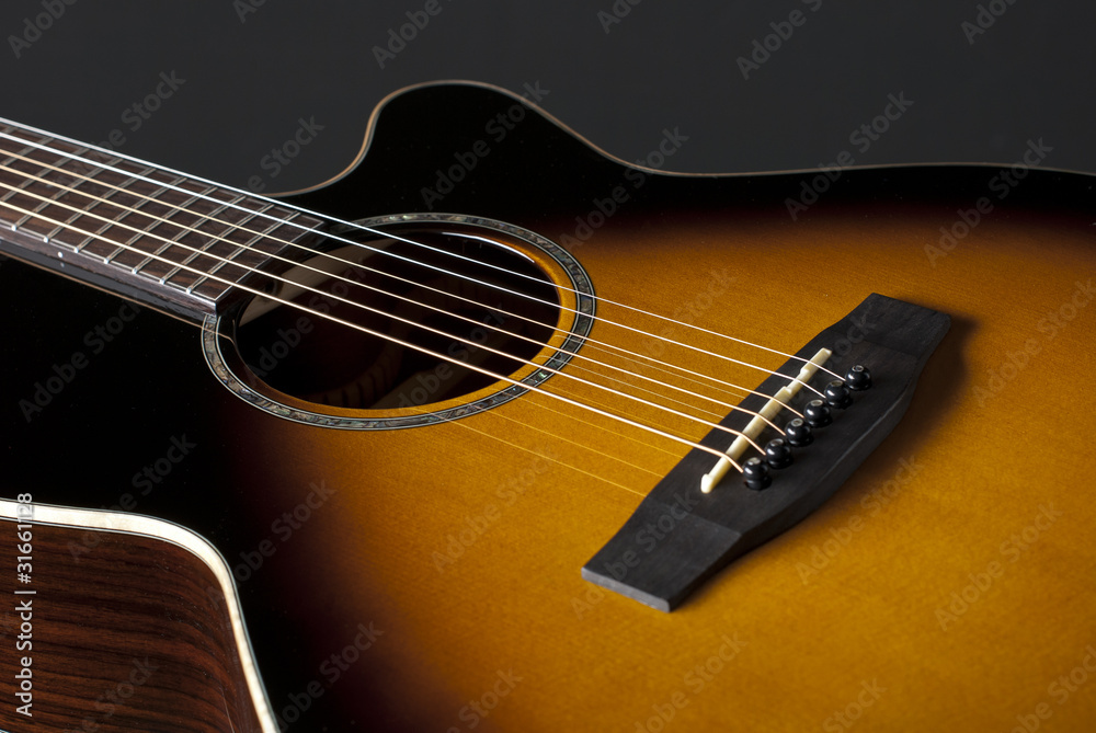 Fototapeta premium Acoustic guitar closeup on dark background