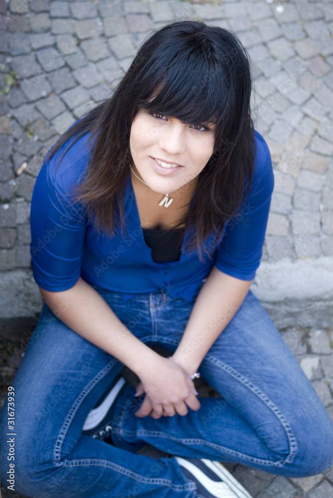Smiling teenage student sitting on steps Smiling teenage student sitting on steps