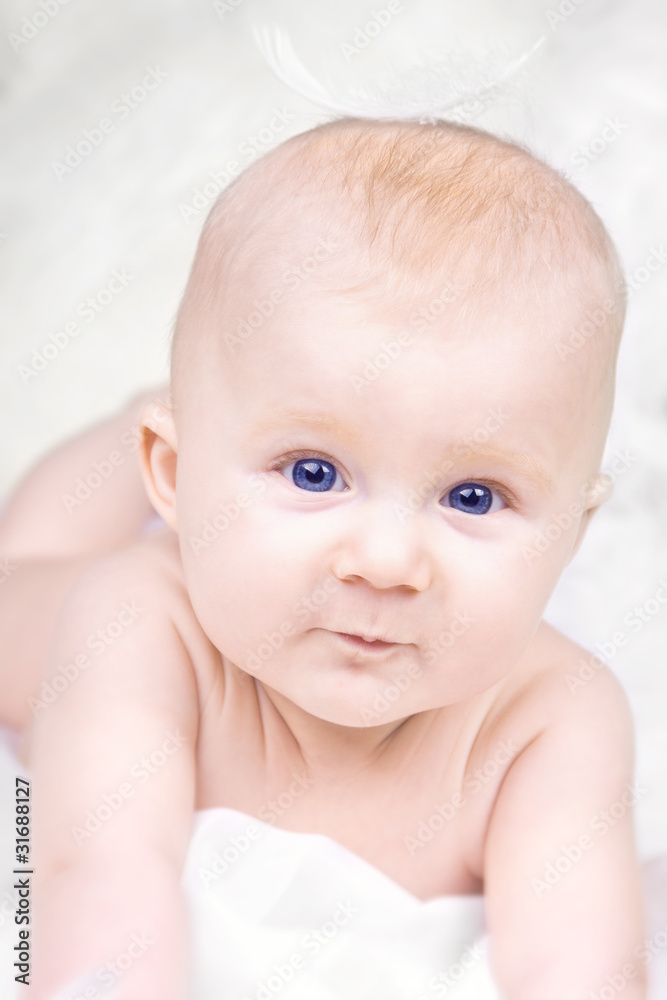 Portrait of happy baby with feather on white background