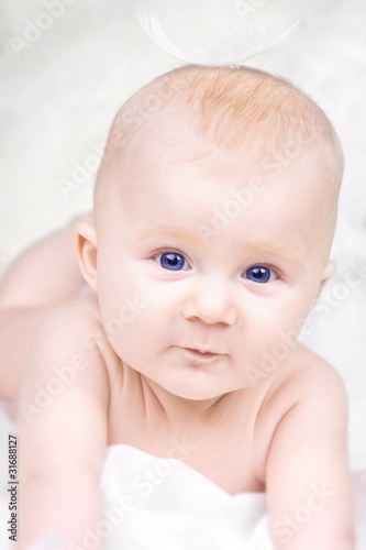 Portrait of happy baby with feather on white background