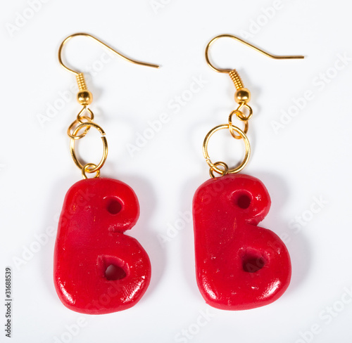 Earrings in the form of a letter B on a white background