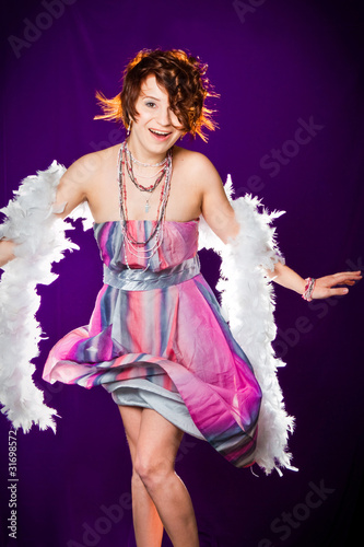 girl with pink dress and white boa posing on purple