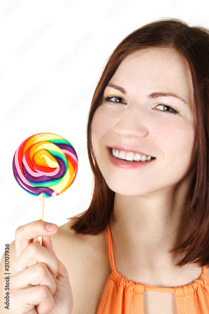 young brunette girl holding big multicolored lollipop and smilin