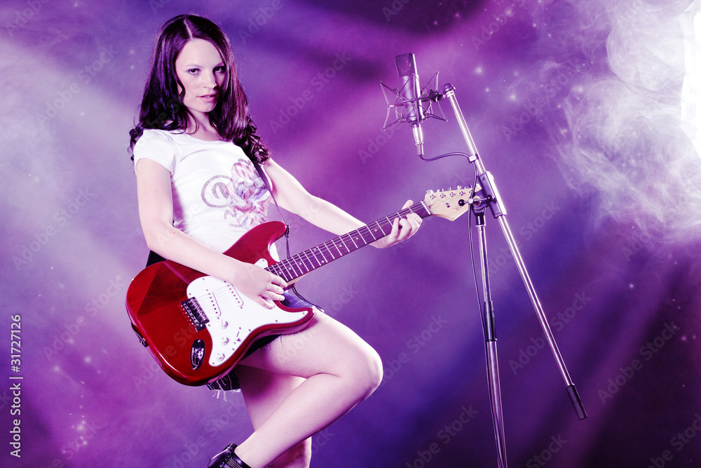 Fototapeta premium Frau mit Gitarre rockt in Lichtfluten Porträt