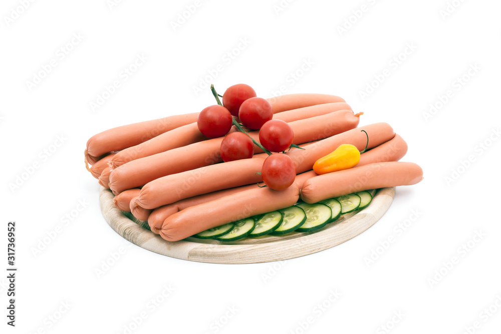 Delicious sausages, served on platter, decorated with vegetables Delicious sausages, served on platter, decorated with vegetables