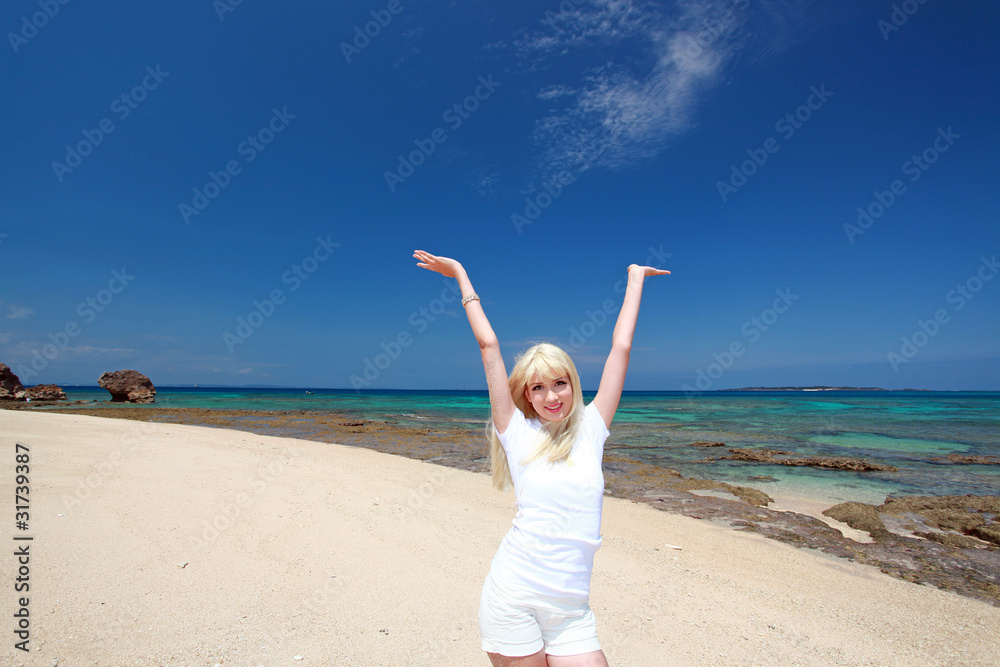 コマカ島の青い空と両手を広げる笑顔の女性