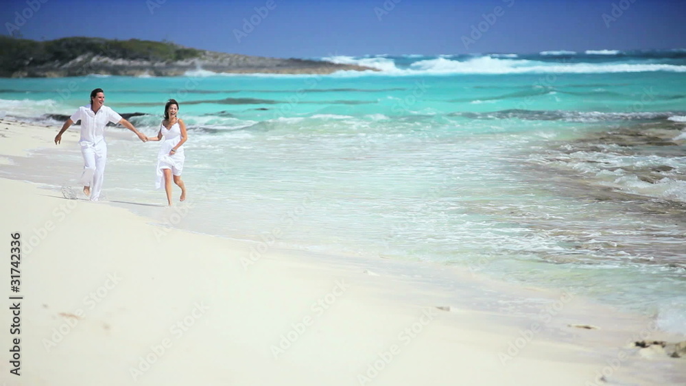 Caucasian Couple Running Along Tropical Beach Caucasian Couple Running Along Tropical Beach