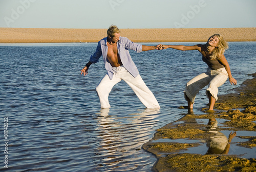 Young attactive couple playing at the beach photo