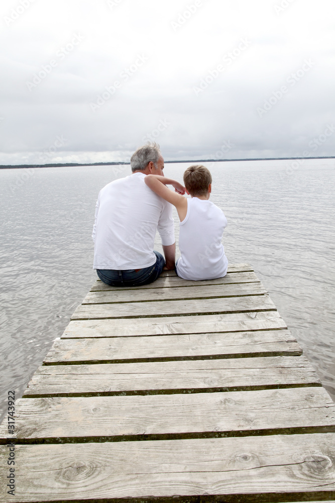 Portrait of father and son sitting on a pontoon
