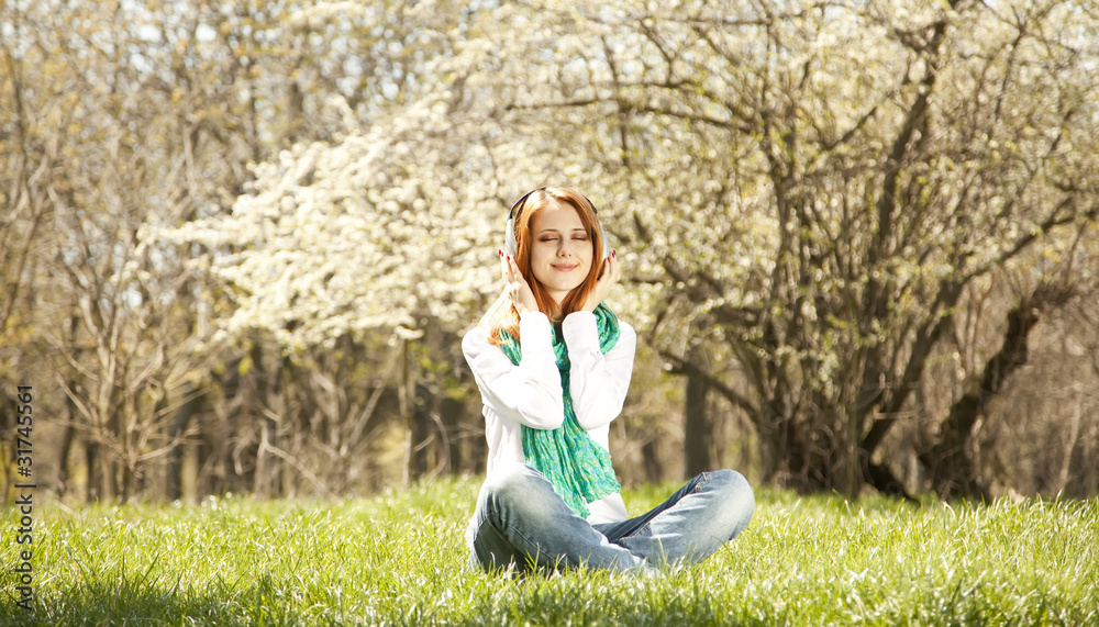 Redhead girl with headphone in the park. Redhead girl with headphone in the park.