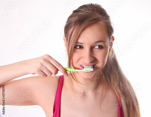 Красивая молодая девушка с зубной щеткой, смотрит в сторону