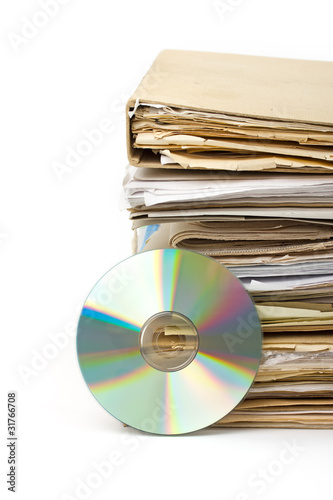 Stack of old paper files and modern archive on cd