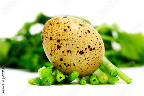 Quail egg on vegetables isolated on white