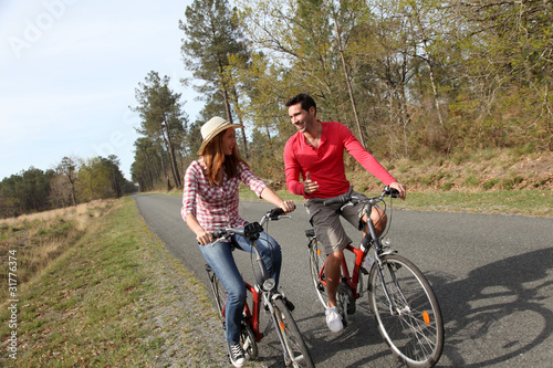 Couple riding bicycles in countryside