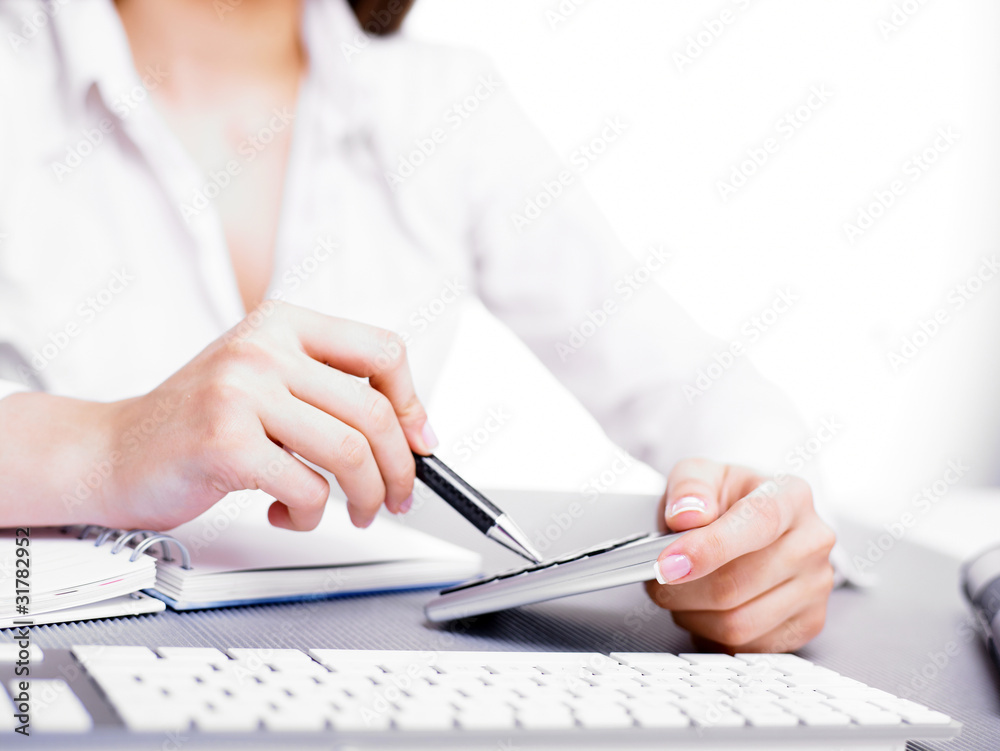 Calculating with calculator and pen Calculating with calculator and pen