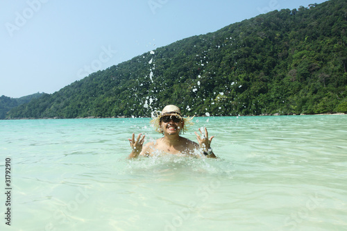 Happy summer, A man making a happy splash in the sea. © akeeris
