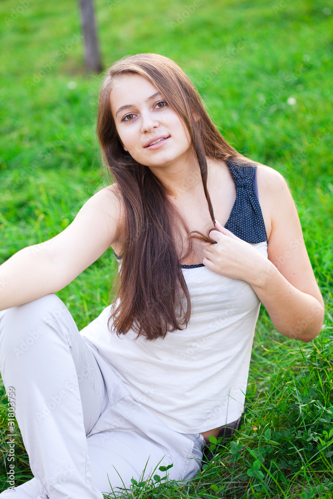 beautiful young woman lying on green grass