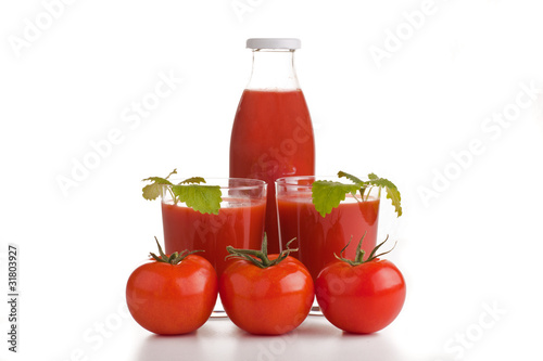 Tomtensaftflasche mit Gläsern und Tomaten