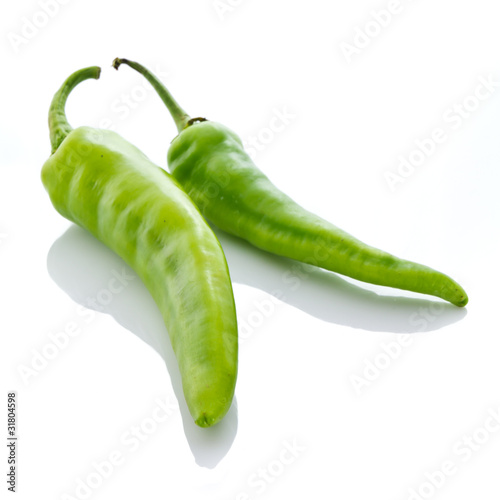 Two green chili on white background