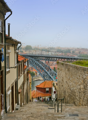 Old street with Dom Luis Bridge view in Porto