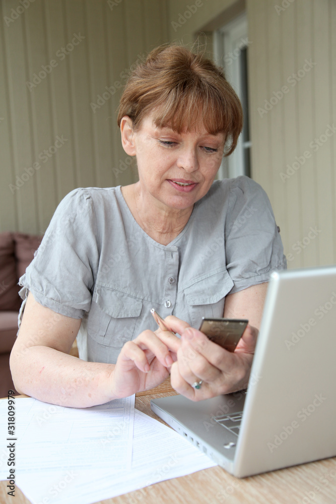 Senior woman filling out form with help of internet Senior woman filling out form with help of internet
