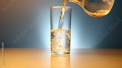 Water pouring and effervescent tablet being dropped into glass