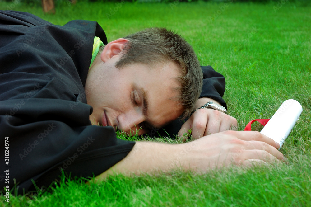 Graduate lay on the grass and closed his eyes Graduate lay on the grass and closed his eyes