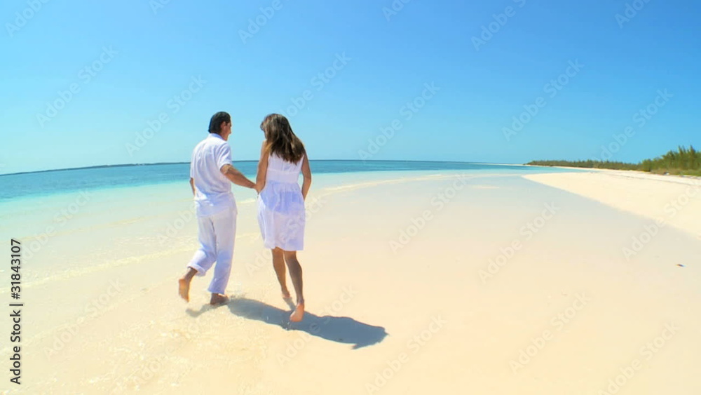 Couple Running in the Shallows Along Tropical Beach Couple Running in the Shallows Along Tropical Beach