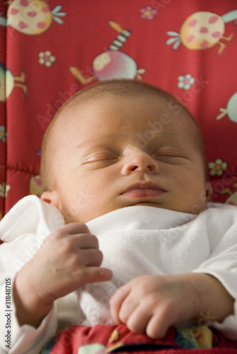 Newborn Baby Boy Sleeping in Red Rocker Chair photo