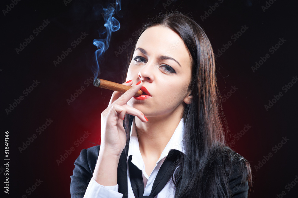 Fototapeta premium Elegant young woman with cigar