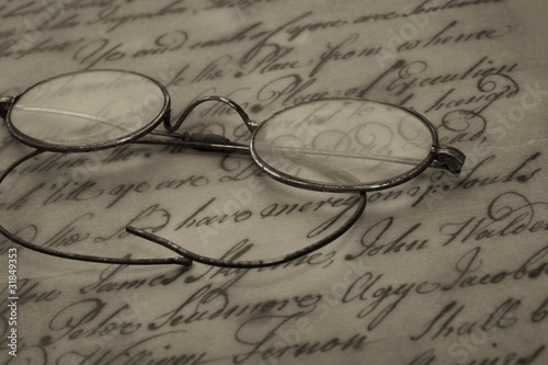 Foto Old glasses on the vintage document