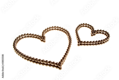 Two hearts of small metal beads on the white