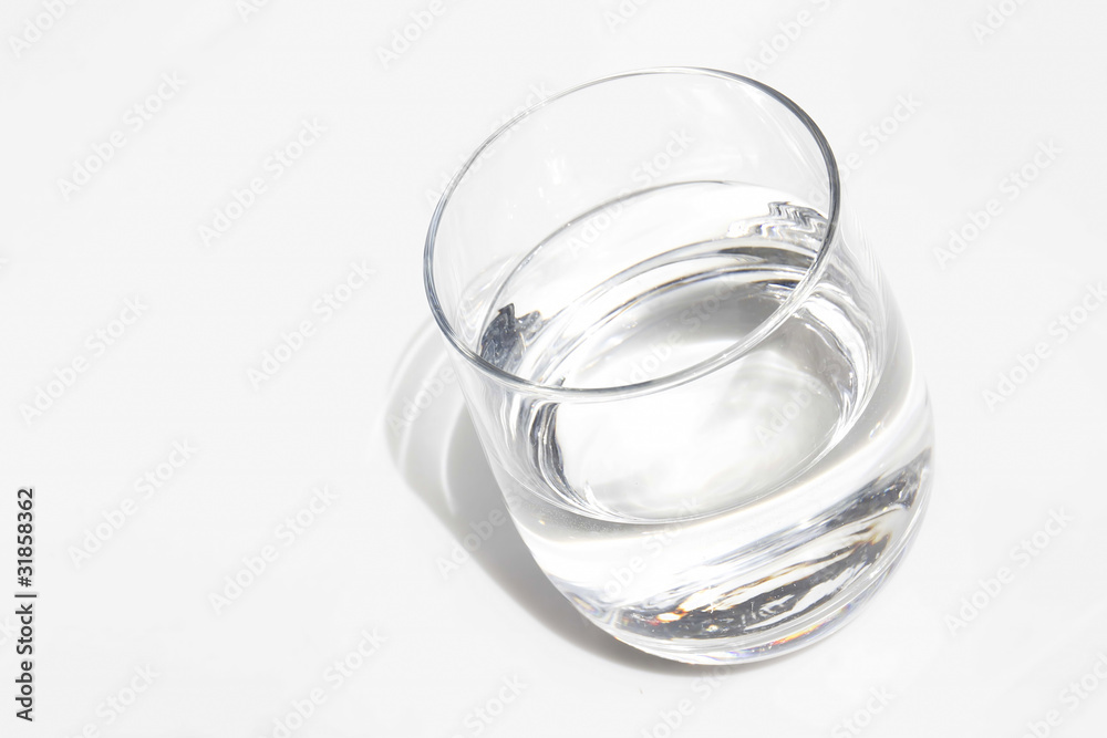 Bicchiere di vetro con acqua su sfondo bianco Bicchiere di vetro con acqua su sfondo bianco