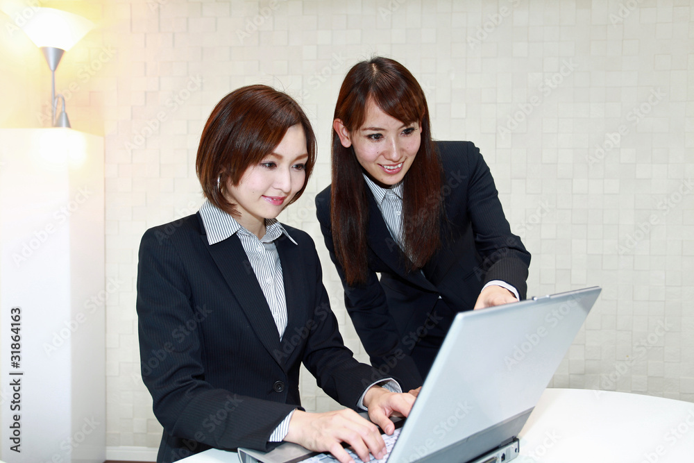 Obraz premium パソコンを見ながら指示を出しているオフィスレディー