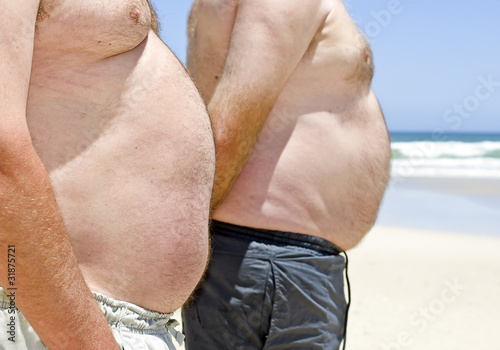 Close up of two obese fat men of the beach
