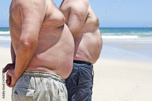 Close up of two obese fat men of the beach