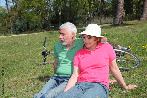 Senior couple riding bicycle in summer