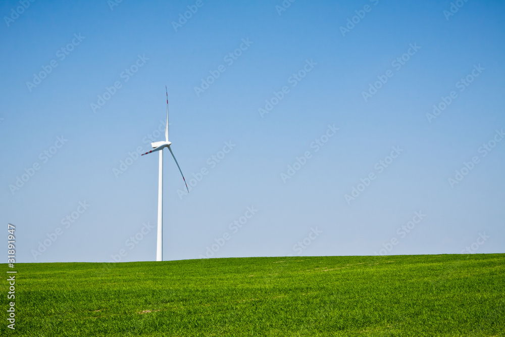 Fototapeta premium Wind turbine on green field